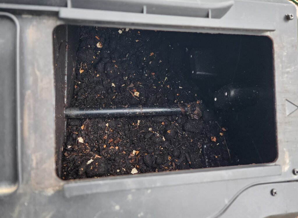 Revived compost bin with dark crumbly compost and visible eggshell pieces breaking down
